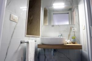 a bathroom with a white sink and a mirror at Casa Noal - a due passi da Ortigia e dal mare in Syracuse +12 photos