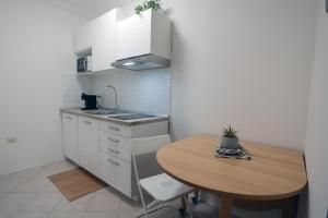 a small kitchen with a wooden table and a wooden table at Casa Noal - a due passi da Ortigia e dal mare in Syracuse