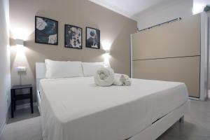 a white bed with a stuffed animal on top of it at Casa Noal - a due passi da Ortigia e dal mare in Syracuse