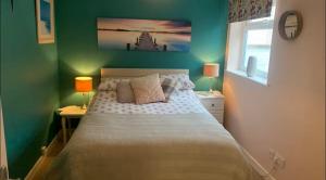Un dormitorio con una cama y dos lámparas sobre mesas. en Cosy, Cute Annnex, en Sidmouth