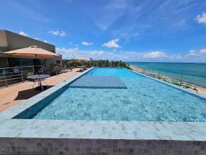 a swimming pool with a view of the ocean at Açores Praia de Tamandaré - À Beira-Mar in Praia dos Carneiros