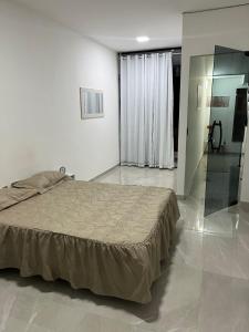 une chambre avec un lit dans une pièce blanche dans l'établissement Casa de alto padrão com hidromassagem aquecida aceita pet perto da praia, à Rio de Janeiro