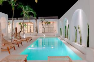 an indoor pool with chairs and a swimming pool at Gili Inlander Boutique Hotel - Adults Only in Gili Trawangan