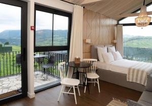 Un dormitorio con una cama y un balcón con mesa y sillas. en Shakaryan Rancho&Restaurant, en Tumanyan
