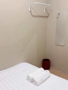 ein Zimmer mit einem Bett mit zwei Handtüchern darauf in der Unterkunft Easy hostel-hotel, 1 min from train station in Hat Yai