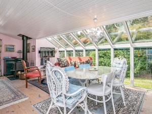 a conservatory with a table and chairs and a couch at 4 person holiday home in Thisted in Thisted