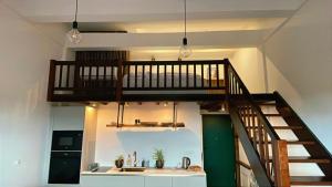 a loft with a staircase and a kitchen with a sink at Nowe Młyny apartament 58 in Leszno
