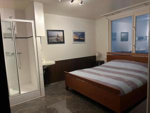 een slaapkamer met een bed, een douche en een wastafel bij Sea Dream in Oostende