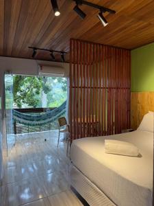 Un dormitorio con una cama con una pared de madera. en Pituba Vile - Apartamento Jardim, en Itacaré
