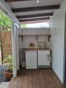an outdoor kitchen with a table on a wooden deck at Bungalow cocon des alizés in Les Abymes