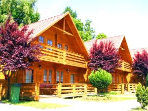 a large wooden house with trees in front of it at Neptun Ψ Domki - Jastrzębia Góra Centrum in Władysławowo