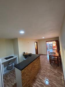 eine leere Küche und ein Wohnzimmer mit einer Arbeitsplatte in der Unterkunft Chalé Levi BG in Barrinha
