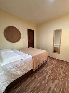 ein Schlafzimmer mit großem Bett und Holzboden in der Unterkunft Chalé Levi BG in Barrinha