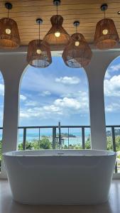 a bath tub in a room with a large window at villaSAMU in Amphoe Koh Samui +2 photos