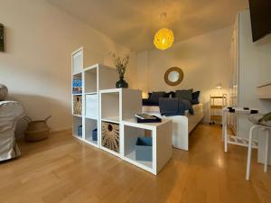 a living room with a white book shelf at Ferienwohnung Am Hunnenbrunnen in Güntersleben