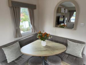 a table and chairs with a vase of flowers on it at Tattershall lakes country park The Fairways in Tattershall