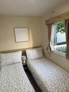 a bedroom with two beds and a window at Tattershall lakes country park The Fairways in Tattershall +14 photos