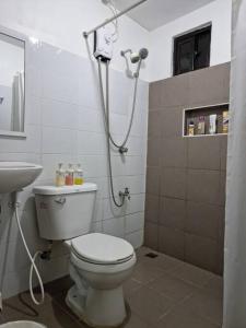 a bathroom with a toilet and a shower at Relaxing 3bedroom home with outdoor dining NUVALI in Calamba
