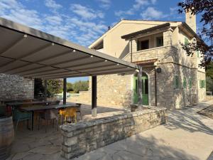 a patio with a table and a stone wall at Relais Borgo San Nicolò in Umag