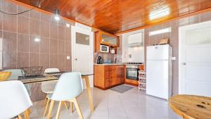 a kitchen with a refrigerator and a table and chairs at Casa Branca in Angra do Heroísmo