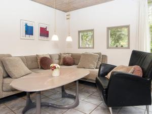 a living room with a couch and a table and chairs at 8 person holiday home in Ørsted-By Traum in Kare