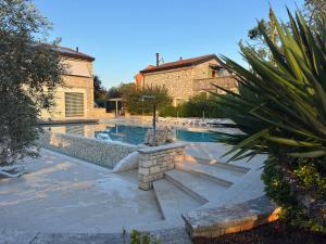 a swimming pool in a yard with a house at Relais Borgo San Nicolò in Umag