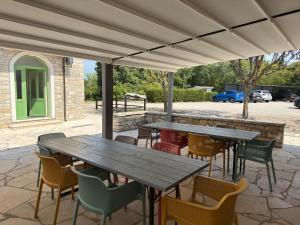 a patio with wooden tables and chairs under a pavilion at Relais Borgo San Nicolò in Umag +9 photos