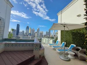 a patio with lounge chairs and an umbrella on a building at Hilton Garden Inn Panama City Downtown, Panama in Panama City