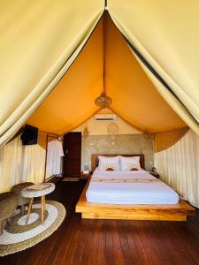 a bedroom with a bed in a tent at Pinggan luxury camp in Baturaja