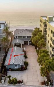 a building with a red sign on it next to the beach at Stones Throw Beachside Bungalow #1 ON THE BEACH in Clearwater Beach