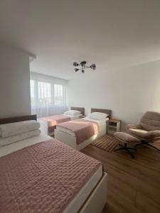 a bedroom with two beds and a chair at WRZOSOVA APARTMENT Tarnów in Tarnów