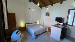 a bedroom with a bed and a desk with a television at Porta Nuova Room Locazione Breve Turistica in Benevento
