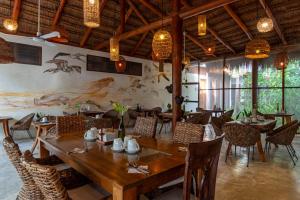 a dining room with a wooden table and chairs at MAJO Hotel Boutique in Holbox Island