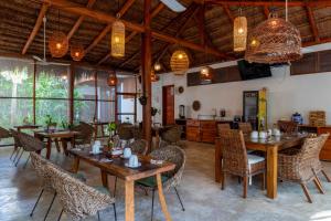 a restaurant with wooden tables and chairs and lights at MAJO Hotel Boutique in Holbox Island