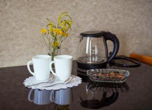 a table with two coffee cups and a tea pot at Family Hotel 7 Sisters in Kazbegi