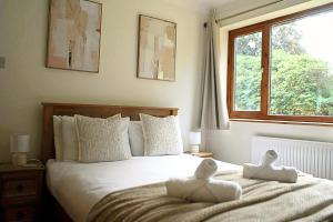 a bedroom with a bed with two stuffed animals on it at Glyndley Manor Cottages in Polegate +112 photos