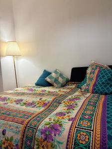a bed with a colorful comforter and a lamp at Studio, paris18, Montmartre in Paris