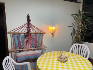 einen Esstisch mit einem gelben und weißen karierten Tischtuch in der Unterkunft Casadarvore in Ponta Delgada