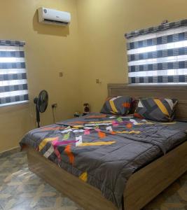 a bedroom with a bed with a colorful comforter at ellas luxury apartments in Abuja