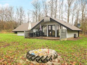 a house with a tire in front of a yard at 6 person holiday home in Roslev-By Traum in Vester Grønning