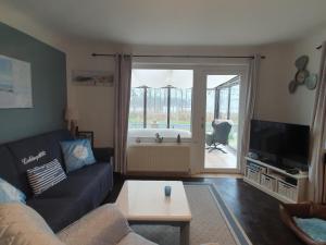 a living room with a couch and a television at Ferienhaus am Nordostseekanal in Offenbüttel