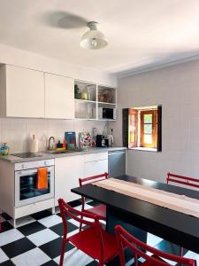 a kitchen with a table and red chairs in it at Quinta da Faísca Guesthouse in Vila do Conde