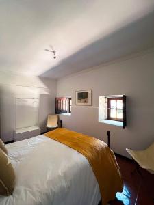 a bedroom with a bed and two windows at Quinta da Faísca Guesthouse in Vila do Conde