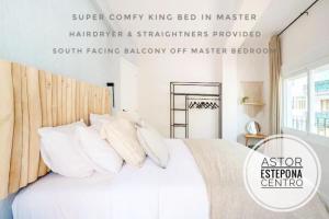 a bedroom with a bed with white sheets and pillows at ASTOR CENTRO. 360 roof terrace. Epicentre old town in Estepona