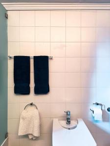 a bathroom with a sink and two black towels at Quinta da Faísca Guesthouse in Vila do Conde +34 photos