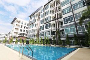 a swimming pool in front of a building at Stylish room Near Central Fest in Chiang Mai