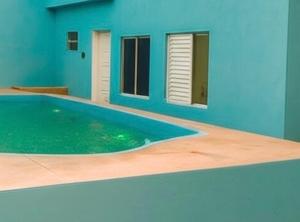 a blue house with a swimming pool in front of it at Pousada Caravela in Penha