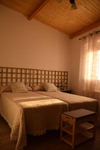 a bedroom with two beds and a window at La Casa Del Sastre in Torrecilla de los Ángeles
