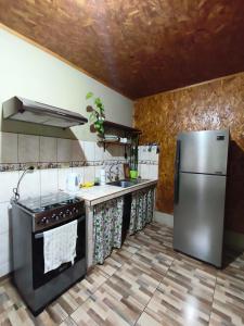 a kitchen with a stainless steel refrigerator and counters at Hospedaje Cattleya in Oxapampa