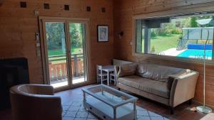 a living room with a couch and a table at Chalet familial au cœur de la Haute Savoie in La Roche-sur-Foron